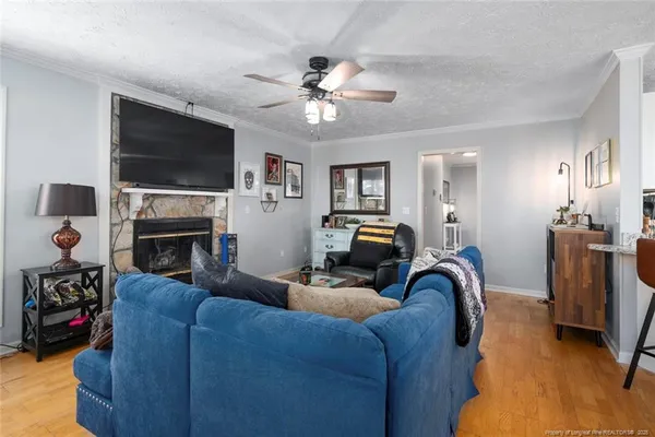 a living room with furniture a flat screen tv and a fireplace