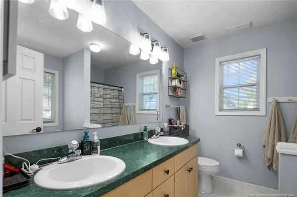 a bathroom with a double vanity sink and a mirror