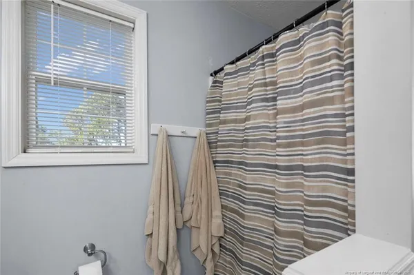 a bathroom with a toilet and a shower curtain