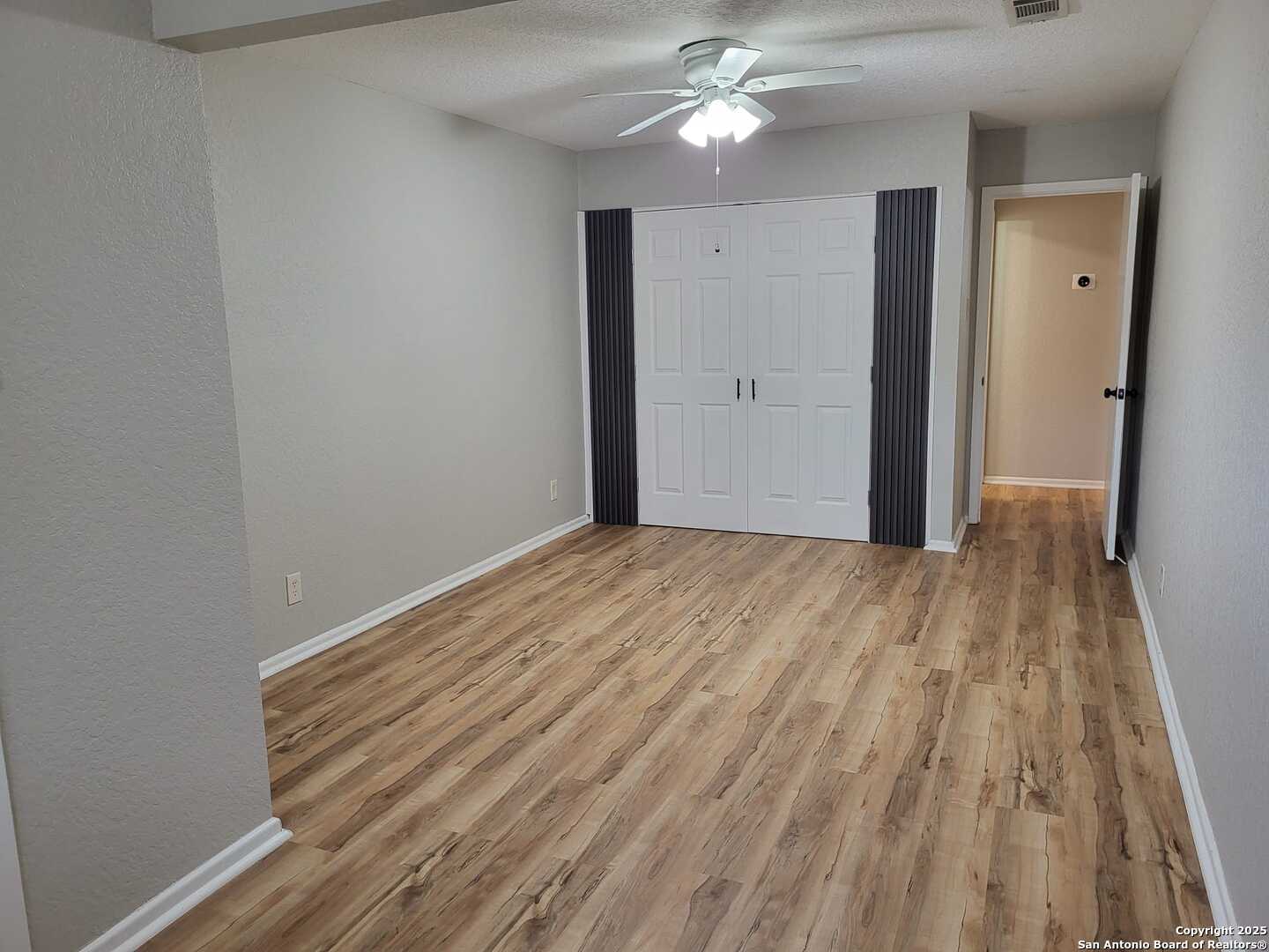 1051 Country Club Drive, Unit 19 Seguin, TX 78155 - Photo 13 of 17 wooden floor in an empty room with a window
