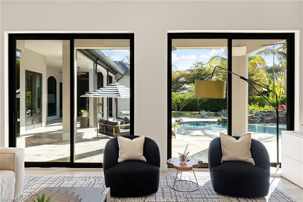 6610 Sable Ridge Lane Naples, FL 34109 - Photo 13 of 47 a living room with furniture and a floor to ceiling window