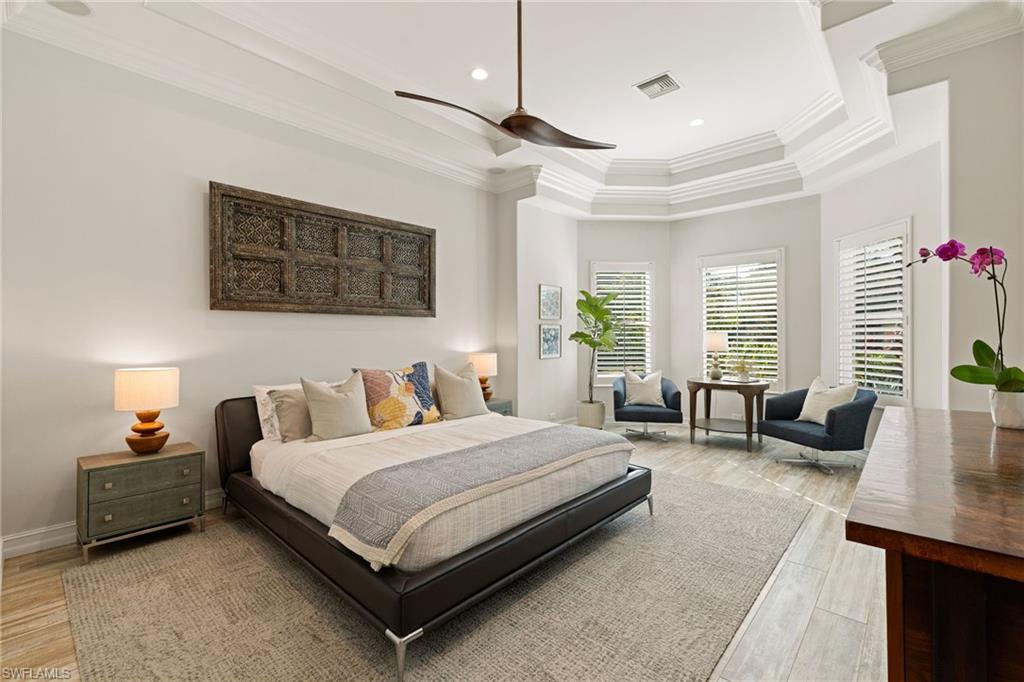 6610 Sable Ridge Lane Naples, FL 34109 - Photo 17 of 47 a bedroom with a bed couch and windows