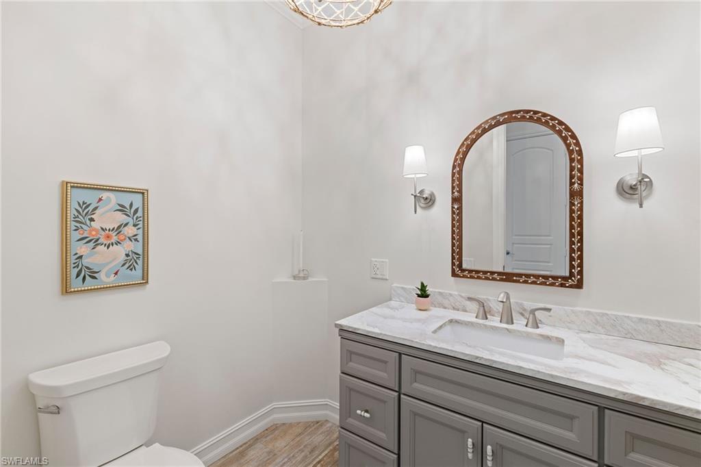 6610 Sable Ridge Lane Naples, FL 34109 - Photo 21 of 47 a bathroom with a granite countertop toilet a sink and a mirror