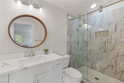 a bathroom with a sink a toilet and a mirror