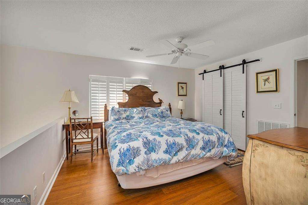 548 Oglethorpe Avenue, Unit 11 St. Simons, GA 31522 - Photo 15 of 25 a bedroom with a bed and a table
