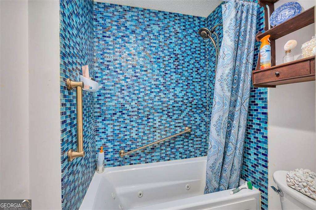 548 Oglethorpe Avenue, Unit 11 St. Simons, GA 31522 - Photo 17 of 25 a bathroom with a bathtub and shower