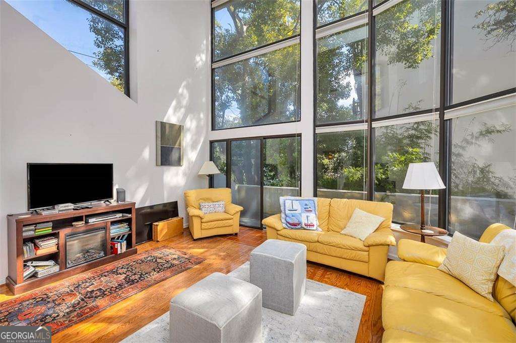 548 Oglethorpe Avenue, Unit 11 St. Simons, GA 31522 - Photo 2 of 25 a living room with furniture tv and a large window
