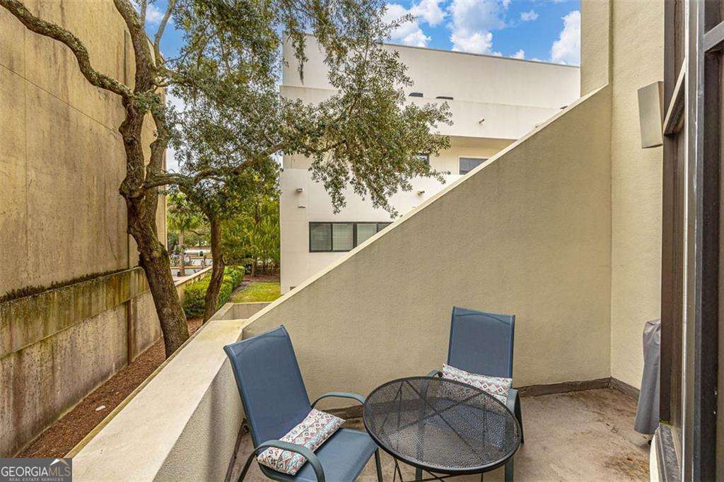 548 Oglethorpe Avenue, Unit 11 St. Simons, GA 31522 - Photo 21 of 25 a balcony with wooden floor and furniture
