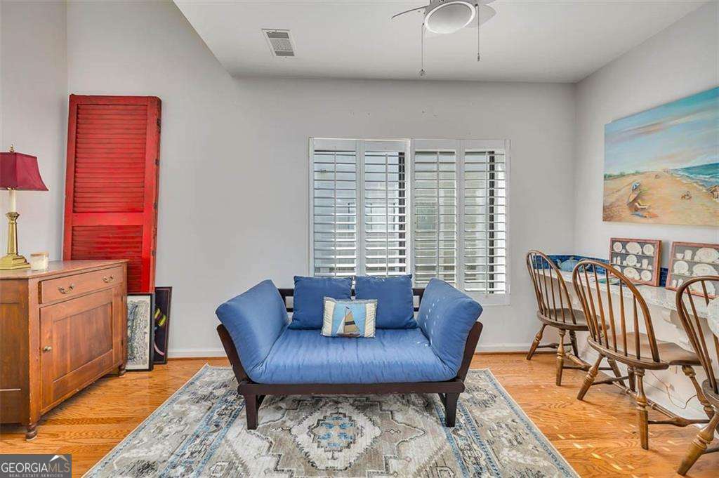 548 Oglethorpe Avenue, Unit 11 St. Simons, GA 31522 - Photo 8 of 25 a living room with furniture and a wooden floor