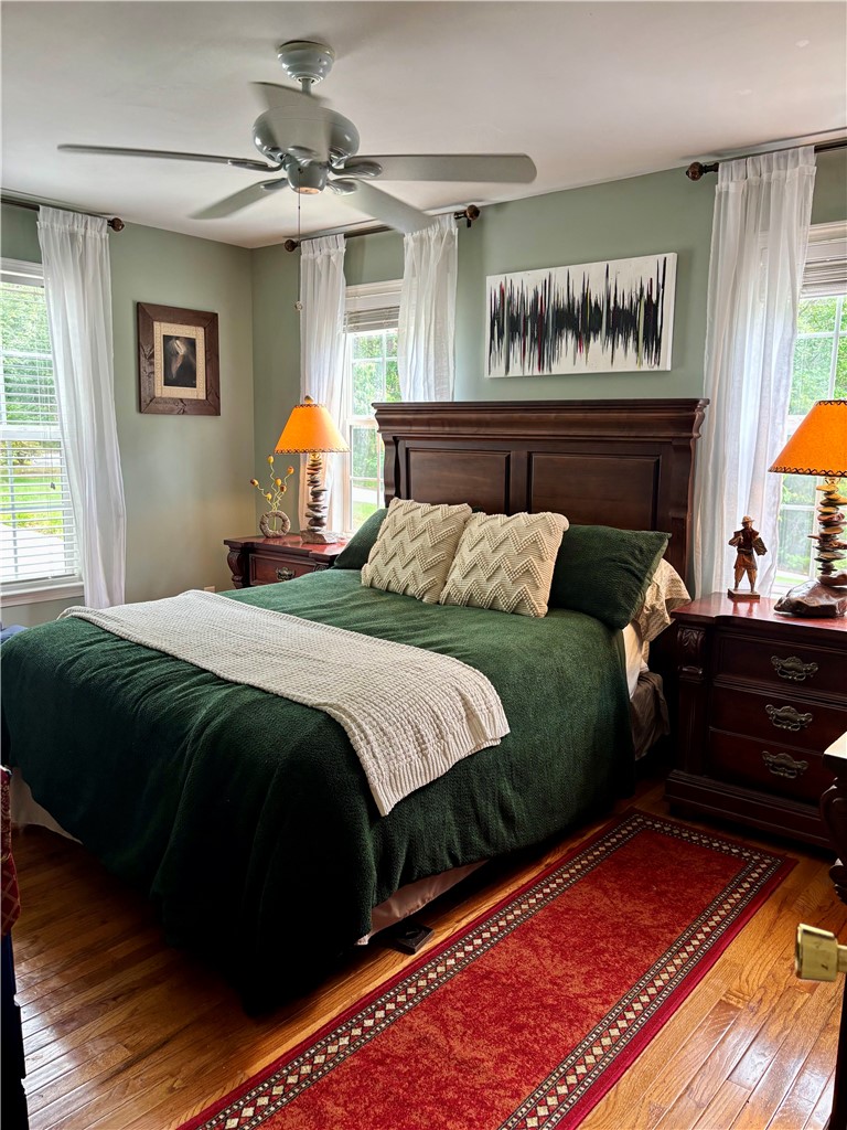 608 McKinney Way Westminster, SC 29693 - Photo 14 of 34 Bedroom with a ceiling fan, hardwood floors, and bright windows create a comfortable retreat.