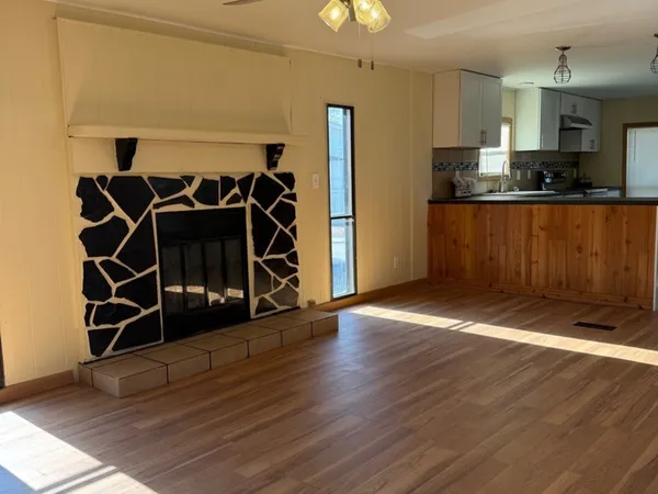 a view of a room with wooden floor and cabinets