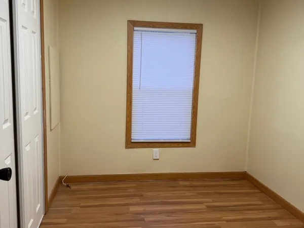 a view of a small space with wooden floor and a window