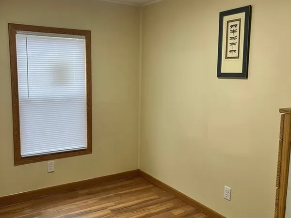 a view of a small space with wooden floor and a window