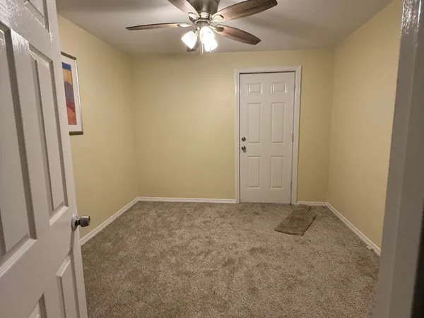 an empty room with closet and a chandelier fan