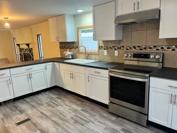 a kitchen with granite countertop white cabinets and white appliances