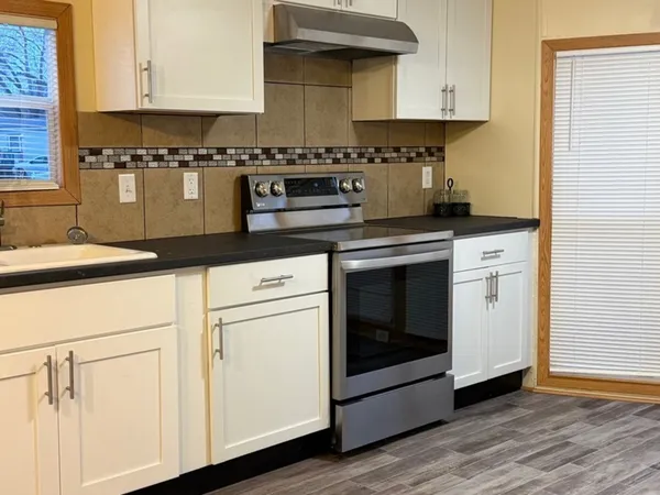 a kitchen with granite countertop white cabinets and white appliances