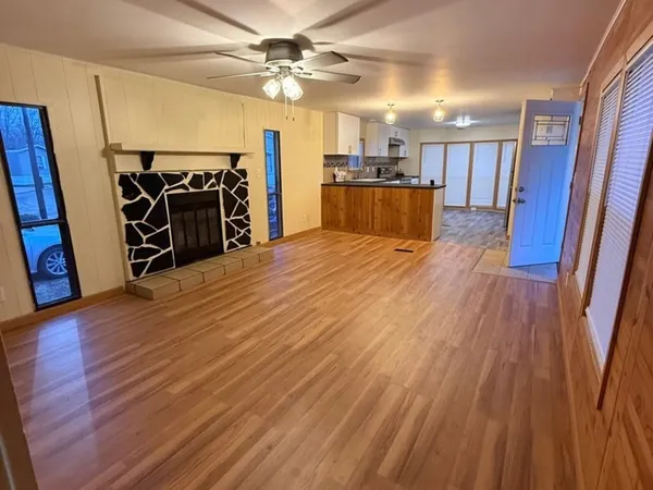 a view of a room with wooden floor and a ceiling fan