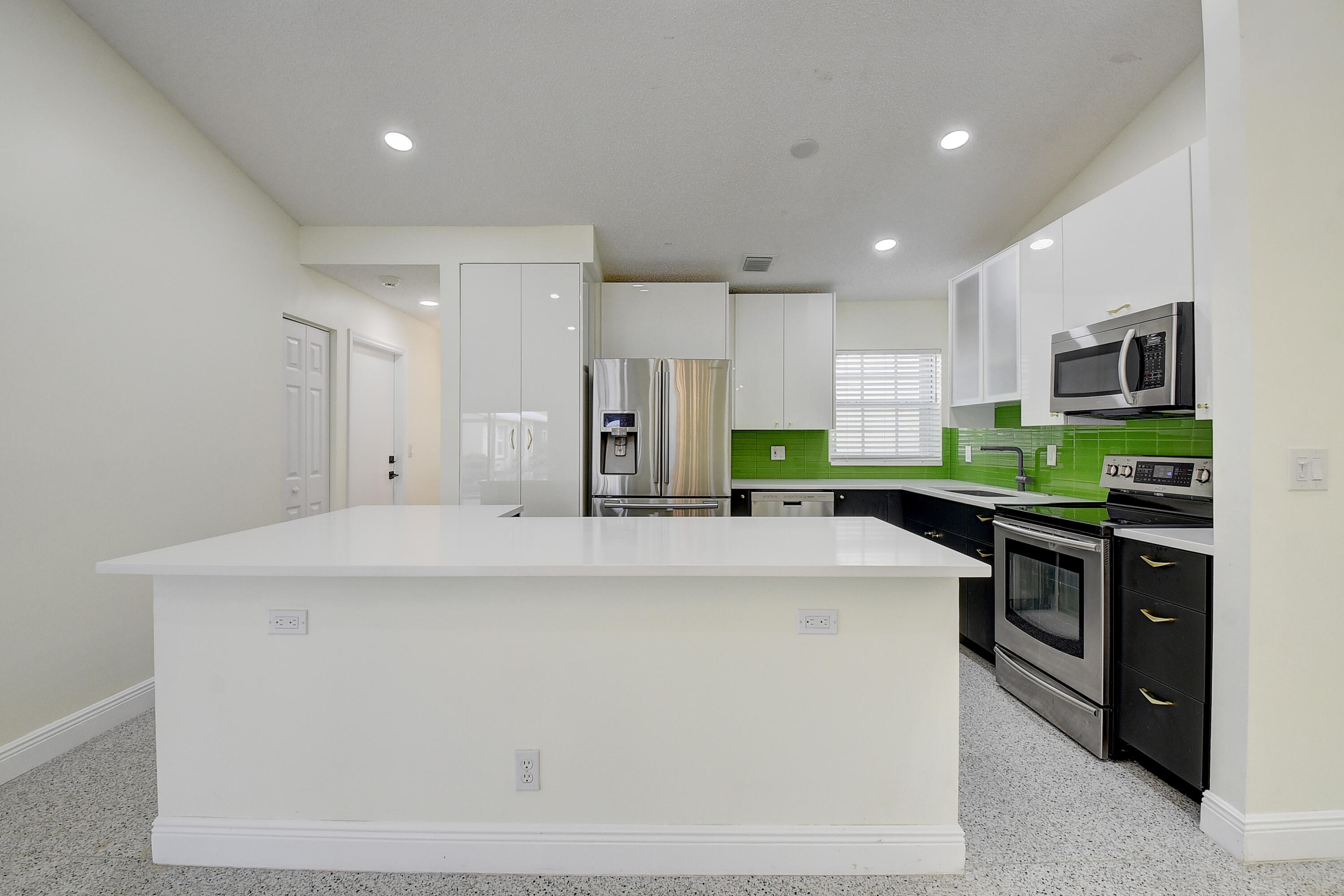 6210 Caladium Road Delray Beach, FL 33484 - Photo 12 of 59 a kitchen with stainless steel appliances a stove sink microwave and cabinets