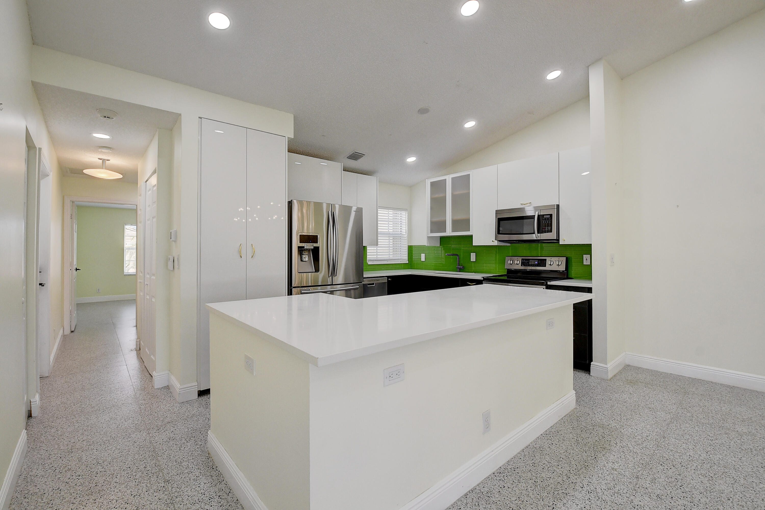 6210 Caladium Road Delray Beach, FL 33484 - Photo 13 of 59 a large white kitchen with stainless steel appliances granite countertop a refrigerator a sink and a stove