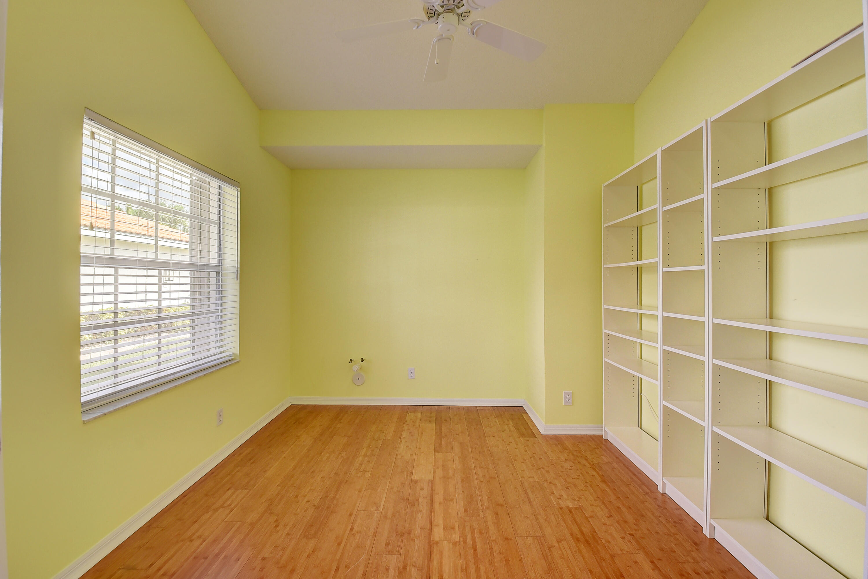 6210 Caladium Road Delray Beach, FL 33484 - Photo 17 of 59 a view of an empty room with a window and wooden floor
