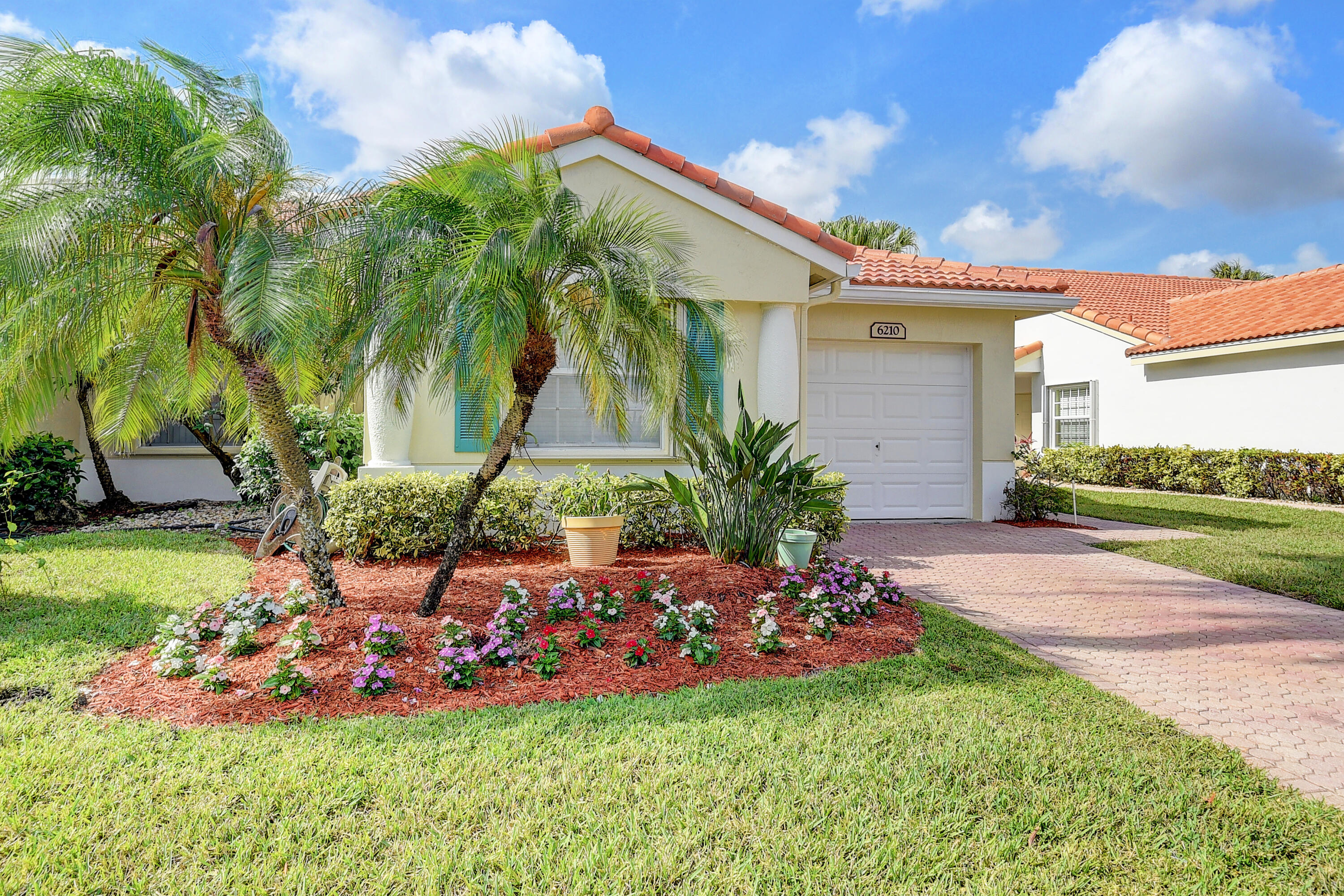 6210 Caladium Road Delray Beach, FL 33484 - Photo 2 of 59 a front view of a house with a yard and garage