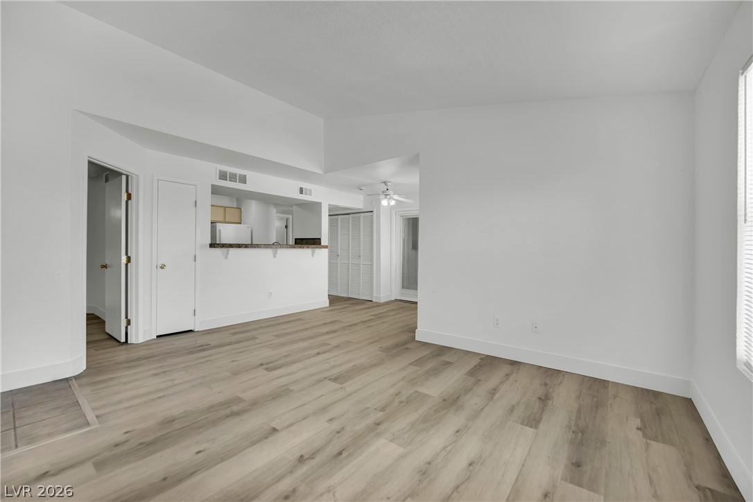 8101 West Flamingo Road, Unit 2030 Las Vegas, NV 89147 - Photo 19 of 27 A well-lit, open-concept living area boasts light wood flooring and a breakfast bar connecting to the kitchen.