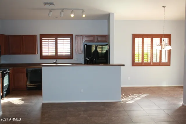 a kitchen with granite countertop a stove a sink and a refrigerator