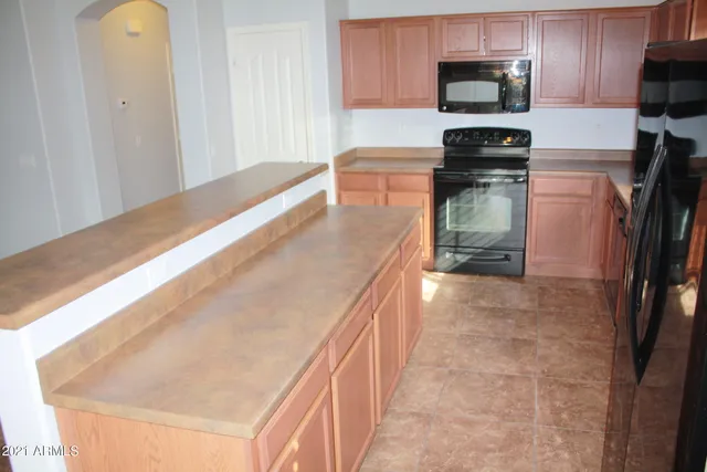 a kitchen with a sink a microwave a refrigerator and cabinets