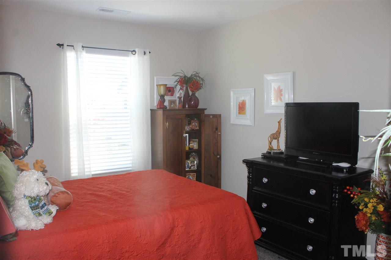3902 Volkswalk Place Raleigh, NC 27610 - Photo 13 of 21 a bedroom with a bed and flat screen tv