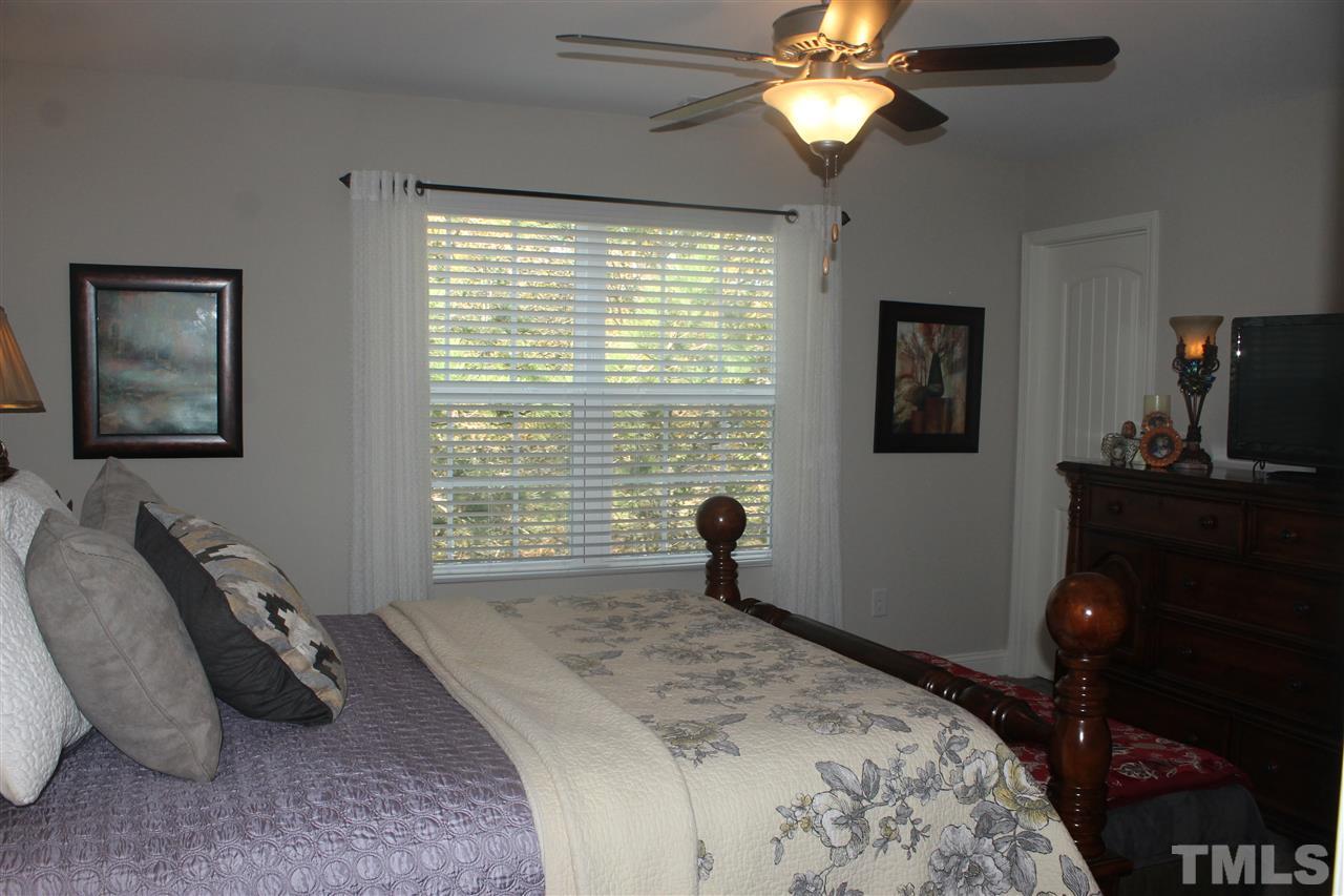 3902 Volkswalk Place Raleigh, NC 27610 - Photo 17 of 21 a bedroom with a bed and a flat tv screen on the dresser