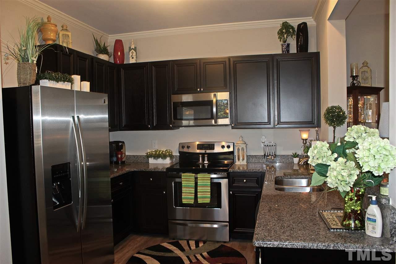 3902 Volkswalk Place Raleigh, NC 27610 - Photo 7 of 21 a kitchen with stainless steel appliances granite countertop a refrigerator a stove top oven a sink and dishwasher