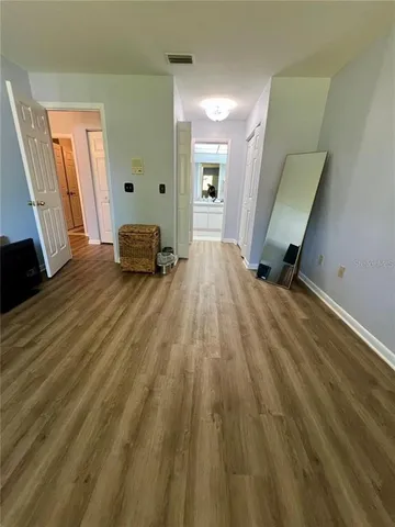 a view of a hallway with wooden floor and staircase