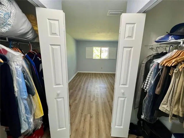 a view of walk in closet with clothes and shoes