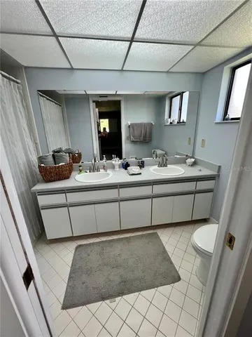 a bathroom with a double vanity sink a mirror and bathtub