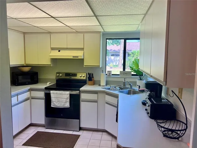a kitchen with a sink cabinets and window