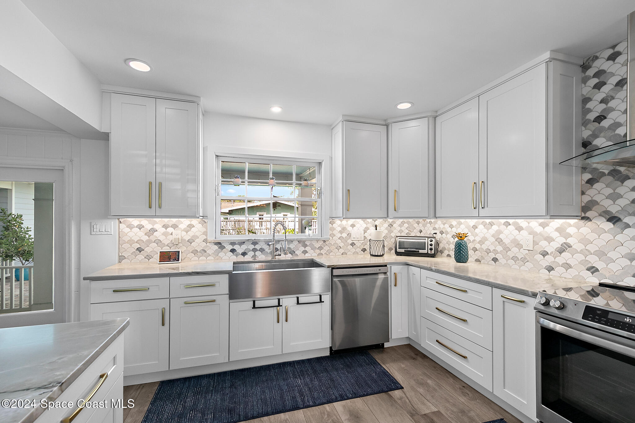 200 Melbourne Avenue Indialantic, FL 32903 - Photo 15 of 60 a kitchen with a sink stove and cabinets