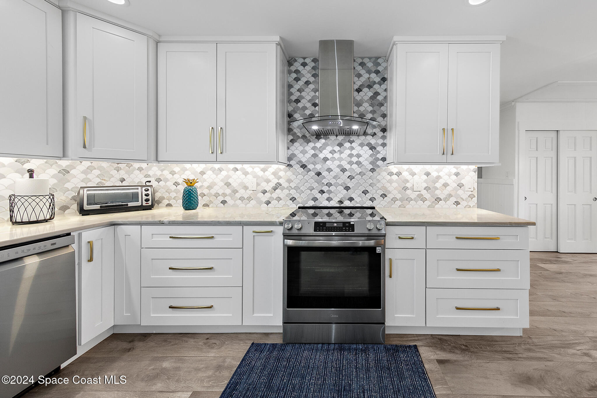 200 Melbourne Avenue Indialantic, FL 32903 - Photo 17 of 60 a kitchen with white cabinets and appliances