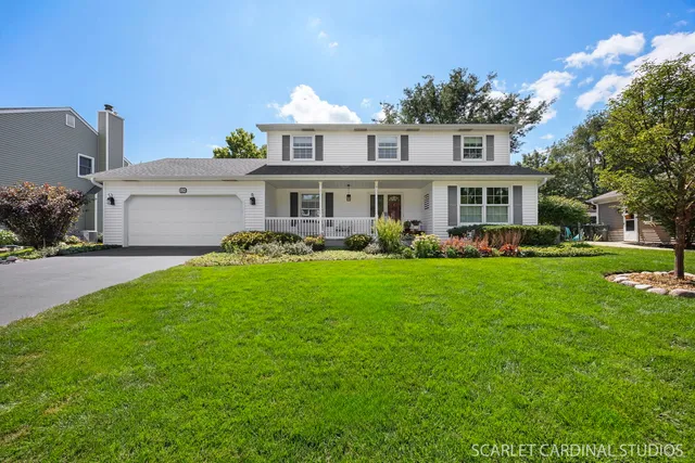 a front view of a house with garden and trees