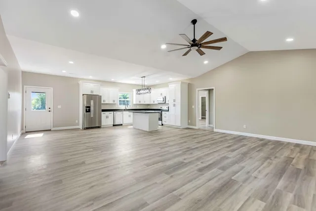 a view of a livingroom with wooden floor and a ceiling fan