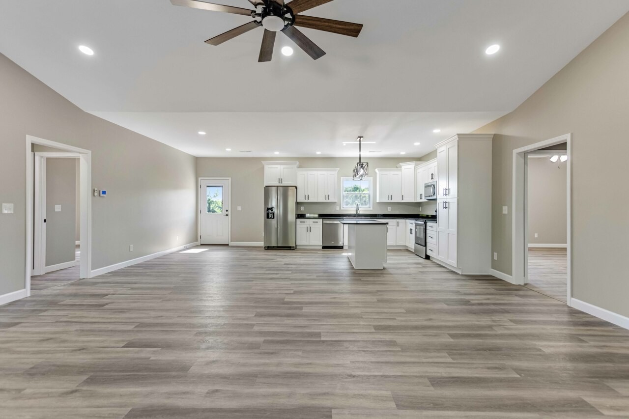 146 Carl Williams Road Crofton, KY 42217 - Photo 7 of 30 a view of an empty room and kitchen view with wooden floor