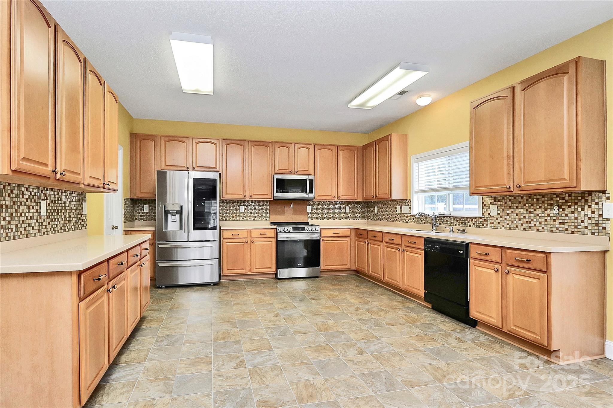 7827 Kuck Road Mint Hill, NC 28227 - Photo 12 of 37 a large kitchen with stainless steel appliances granite countertop a stove a sink dishwasher a refrigerator and white cabinets with wooden floor