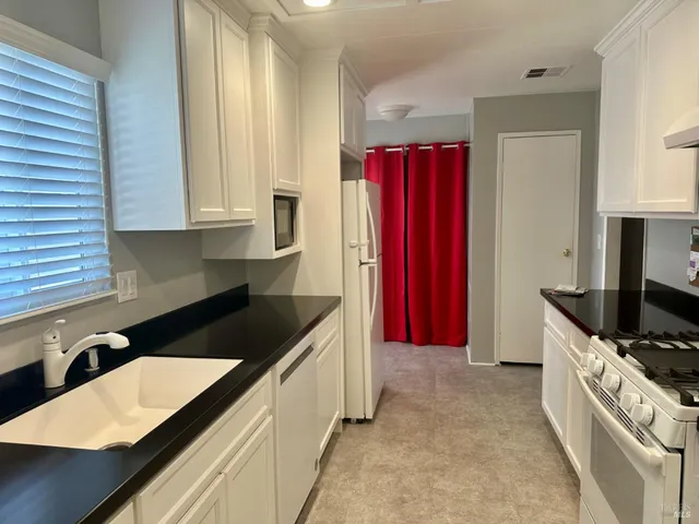 a kitchen with a sink a stove and a microwave