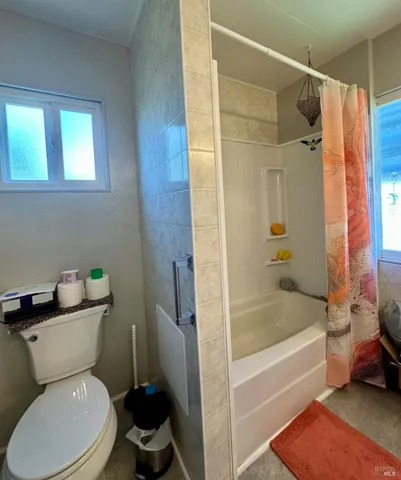 a bathroom with a toilet and a shower