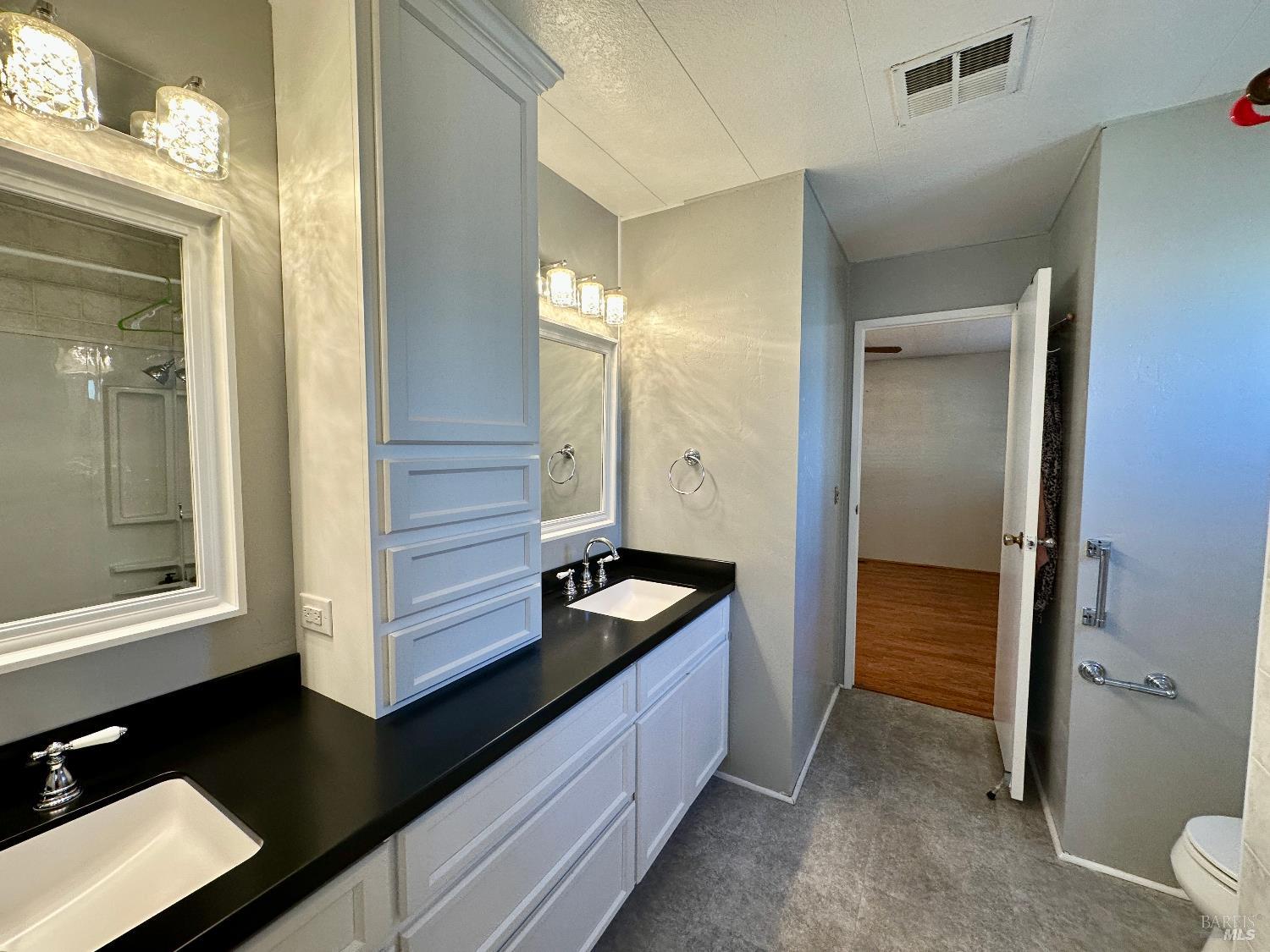102 Royal Oak Court, Unit 102 Fairfield, CA 94533 - Photo 21 of 32 a bathroom with a granite countertop sink and a mirror