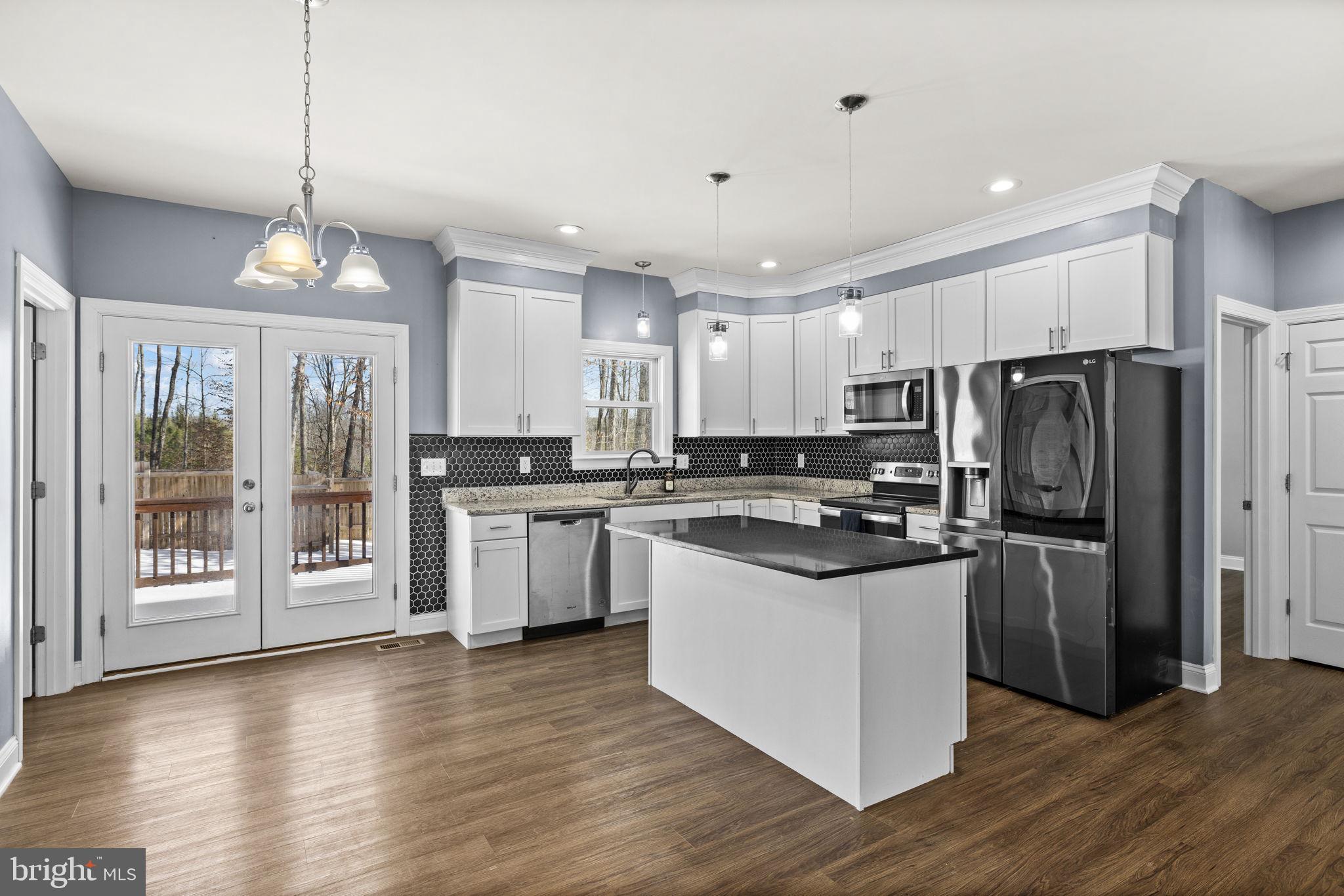 820 Kennon Road Mineral, VA 23117 - Photo 3 of 43 a kitchen with stainless steel appliances granite countertop a refrigerator a stove top oven a sink dishwasher a refrigerator and white cabinets with wooden floor