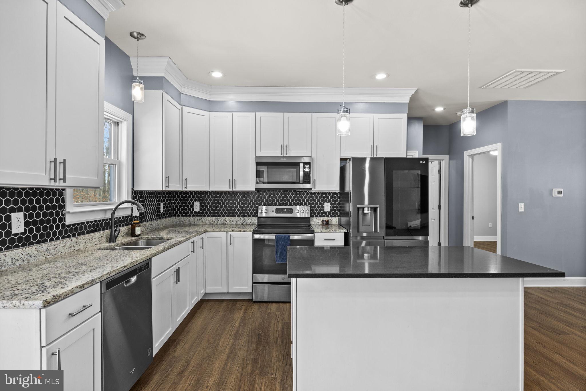 820 Kennon Road Mineral, VA 23117 - Photo 5 of 43 a kitchen with stainless steel appliances granite countertop a sink refrigerator and cabinets