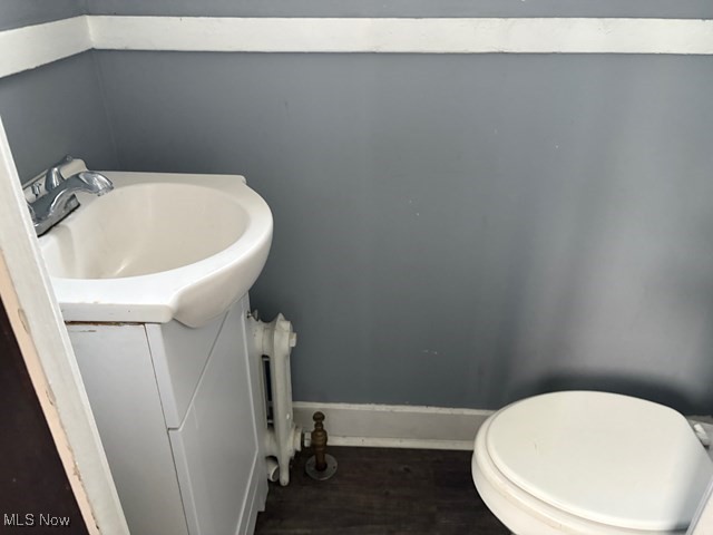 3258 Berkshire Road Cleveland, OH 44118 - Photo 21 of 23 Half bath featuring vanity, wood finished floors, and radiator