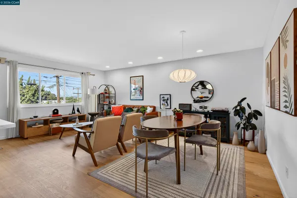 a living room with furniture a table and kitchen view