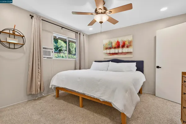 a bedroom with a bed and paintings on the wall