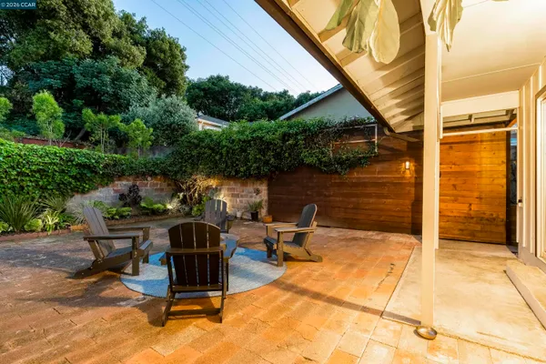 a view of a backyard with table and chairs and potted plants